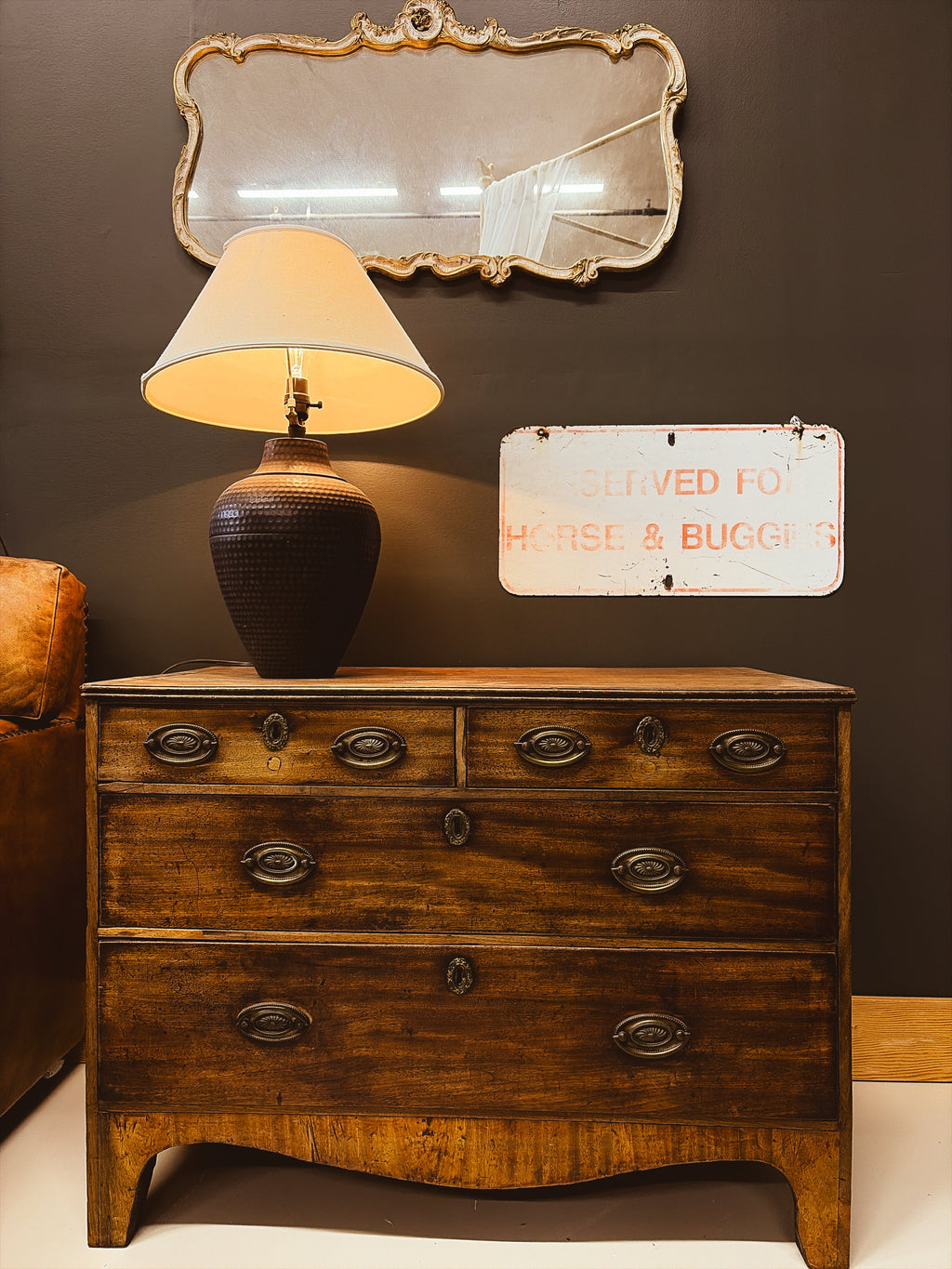 Georgian bow-front walnut chest of drawers — styled with lamp and mirror